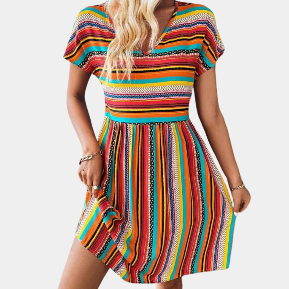 Vrouw in kleurrijke gestreepte zomerjurk met korte mouwen, oranje en regenboogstrepen, casual mode, strandkleding, trendy dameskleding.