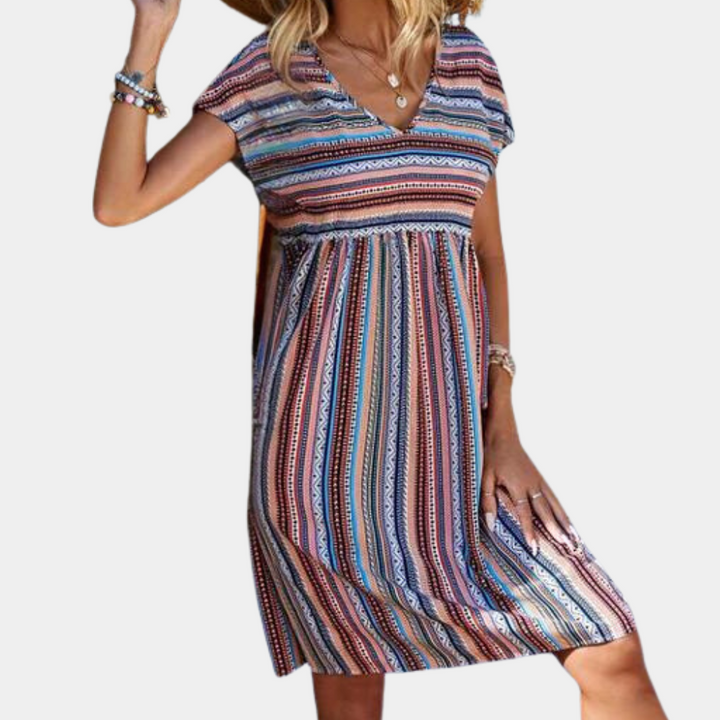 Vrouw in kleurrijke gestreepte zomerjurk met V-hals en korte mouwen, ideaal voor casual strandoutfits. Trendy damesmode, boho-stijl jurk.
