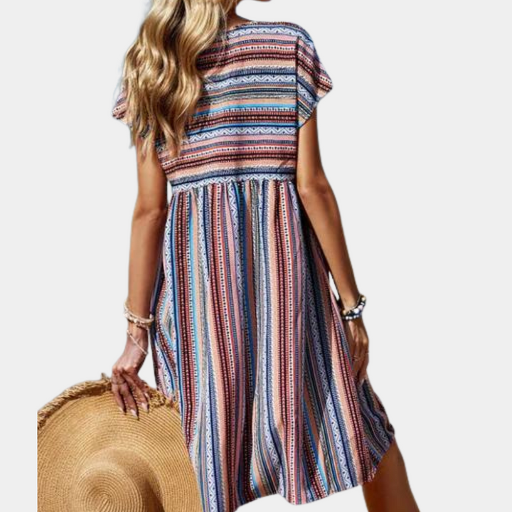 Vrouw in kleurrijke gestreepte zomerjurk met hoed, strandkleding, bohemian stijl, casual mode, achteraanzicht, trendy dameskleding.