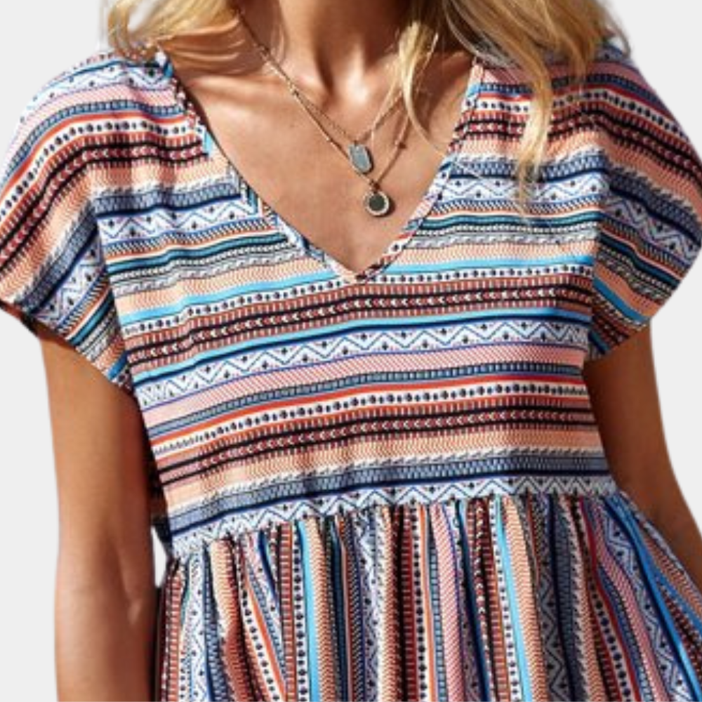 Vrouw in kleurrijke boho-jurk met geometrisch patroon, V-hals en korte mouwen. Trendy zomeroutfit, casual stijl, modieuze dameskleding.