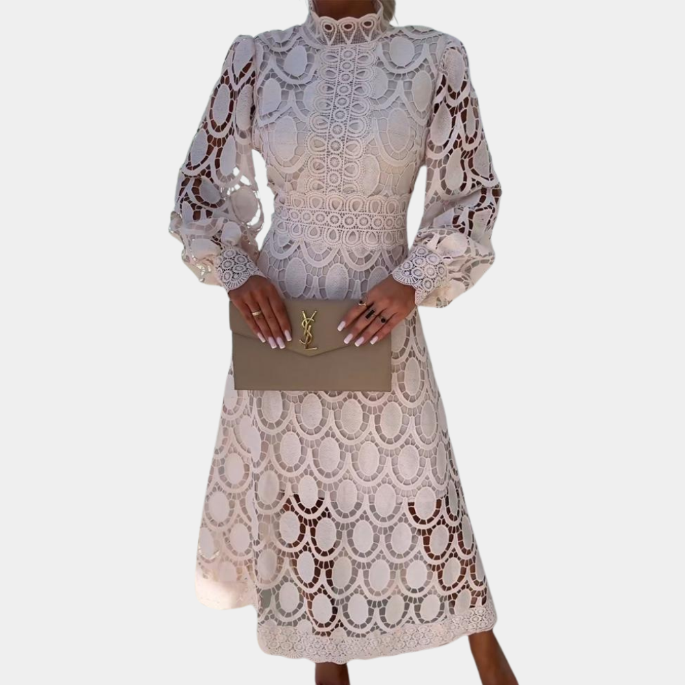 Vrouw in elegante beige kanten jurk met lange mouwen, houdt een designer clutch vast. Perfect voor bruiloften en formele evenementen.