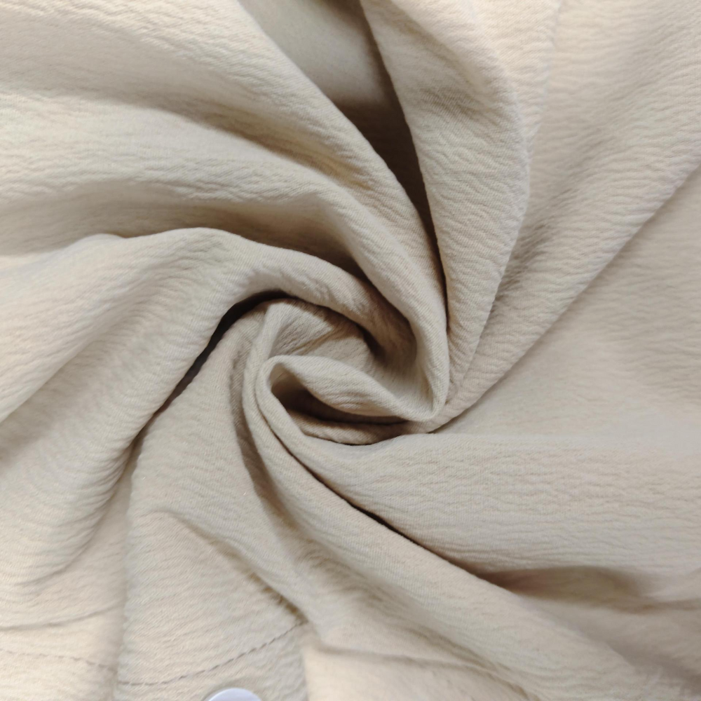 Beige kreukvrije stof close-up, gedraaid patroon, textieltextuur, geschikt voor modeontwerp en interieurdecoratie.