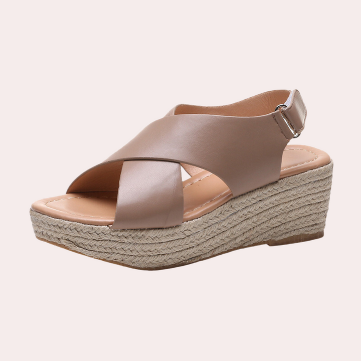 Beige leren dames sandaal met sleehak, gevlochten touwzool en verstelbare band. Comfortabele zomerschoen, modieus en veelzijdig.