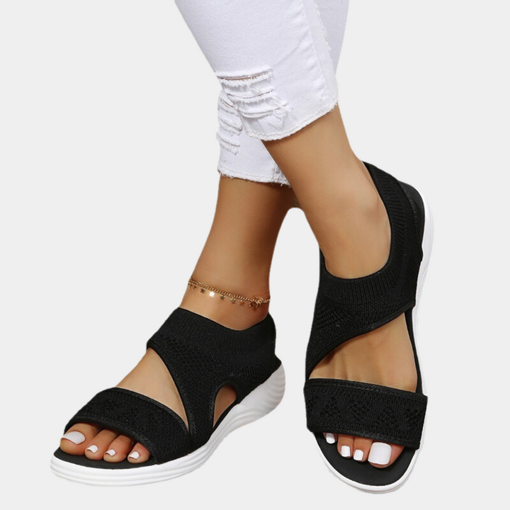 Zwarte dames sandalen met open teen en elastische band, comfortabele witte zool, ideaal voor zomerse casual outfits. Trendy en stijlvol schoeisel.