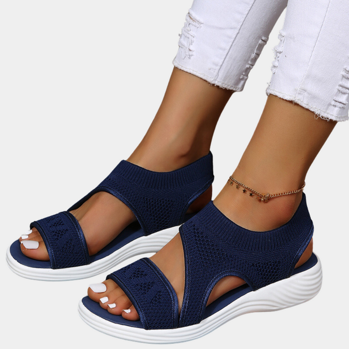 Donkerblauwe dames sandalen met elastische band, ademend mesh, en witte zool. Comfortabele zomerschoenen, ideaal voor casual outfits.