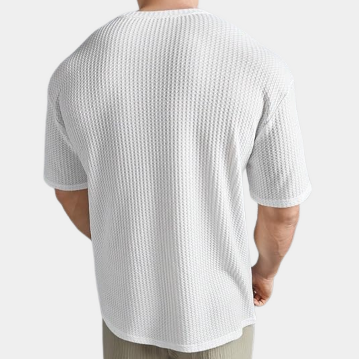 Witte heren T-shirt met textuur, korte mouwen en ronde hals, gedragen door een man. Perfect voor casual en sportieve outfits.