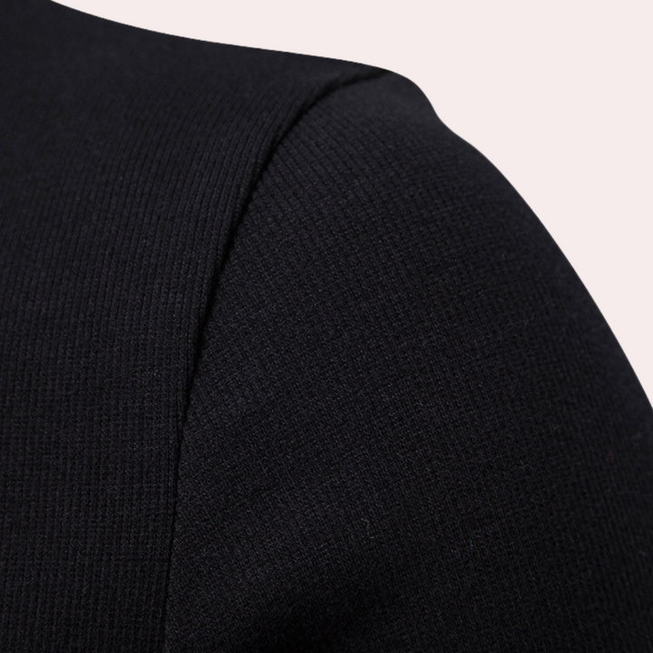 Zwarte ribgebreide trui detail, close-up van schouder en mouw. Hoogwaardige stof, modieuze herenkleding, minimalistisch ontwerp.