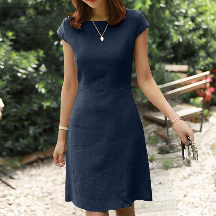 Vrouw in elegante donkerblauwe jurk, zomerkleding, buitenomgeving, stijlvolle mode, casual chique, dameskleding, trendy outfit, tuin.