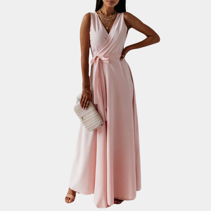 Elegante roze maxi-jurk met V-hals en strikceintuur, perfect voor zomerfeesten. Draag met sandalen en een clutch voor een stijlvolle look.