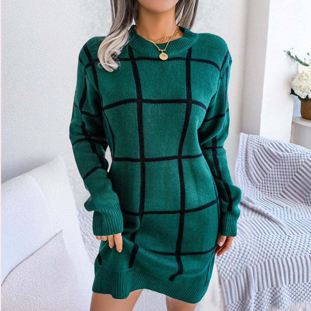 Vrouw in groene geruite trui jurk, comfortabele wintermode, stijlvolle dameskleding, trendy outfit, woonkamer achtergrond, gouden ketting.