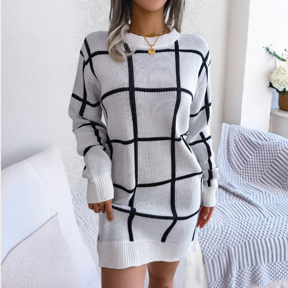 Vrouw in witte trui jurk met zwart ruitpatroon, casual mode, comfortabele woonkamer, trendy dameskleding, herfst winter outfit.