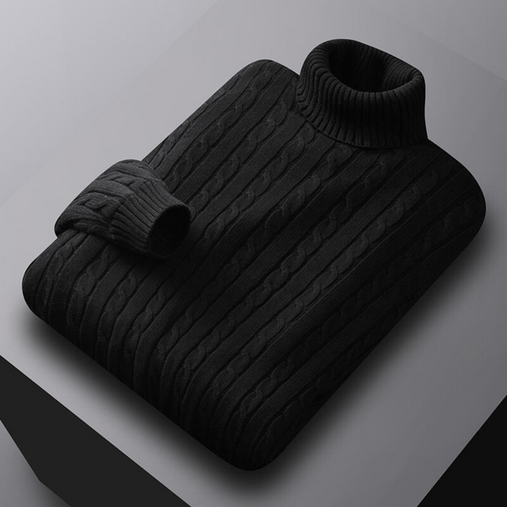 Zwarte kabeltrui met col, opgevouwen op een grijze achtergrond. Stijlvolle herentrui, warme wintermode, gebreide kleding.