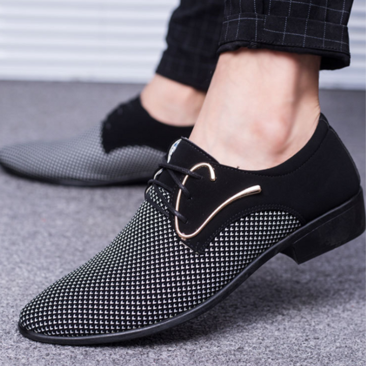Zwart-witte herenschoenen met metalen decoratie, stijlvolle veters en geruit patroon. Perfect voor formele gelegenheden en modieuze outfits.