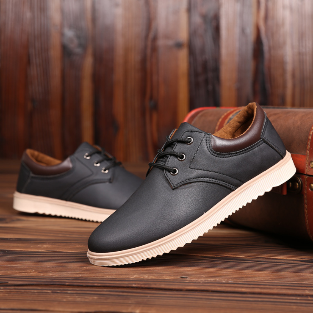 Zwarte leren herenschoenen met bruine accenten, casual stijl, op houten vloer. Comfortabele veterschoenen, perfect voor dagelijks gebruik.