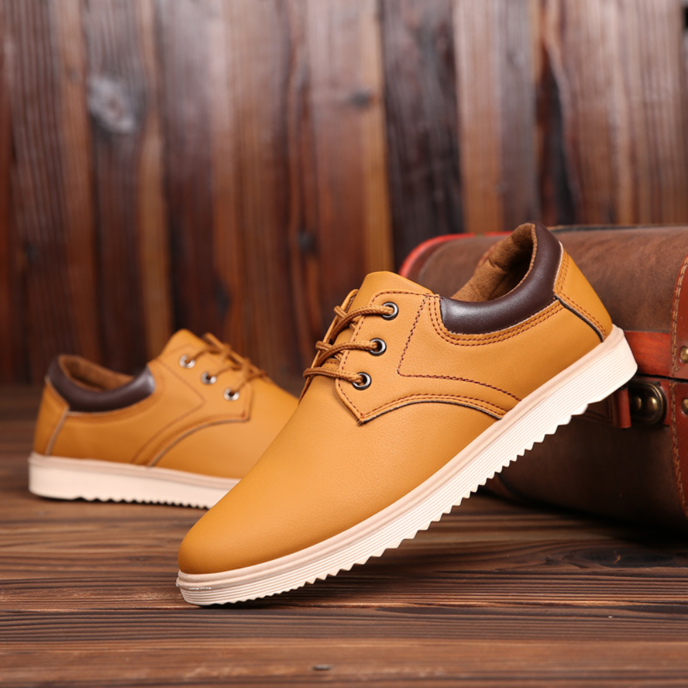 Gele leren herenschoenen met bruine accenten, casual stijl, op houten vloer. Perfect voor modieuze, comfortabele herenschoenen.