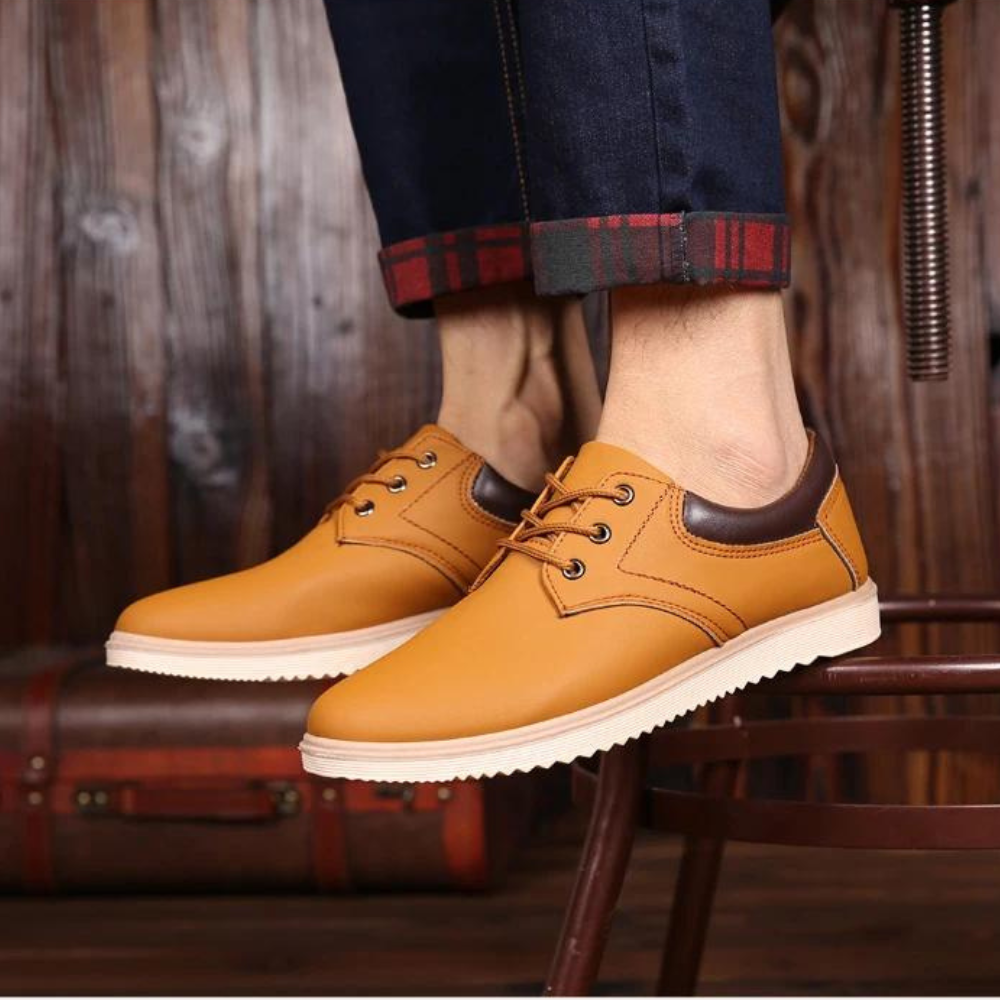 Gele leren herenschoenen met bruine accenten, casual stijl, gedragen met opgerolde jeans. Perfect voor modieuze, comfortabele herenschoenen.