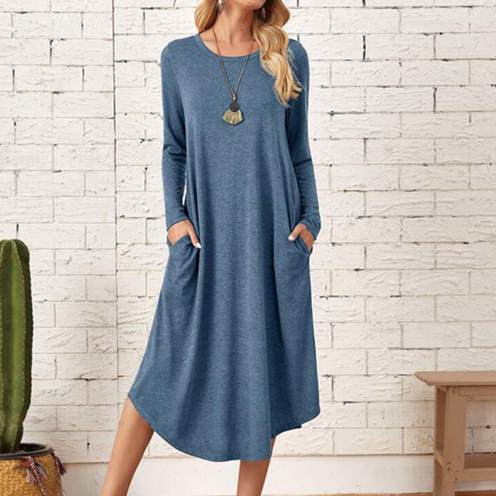 Blauwe casual damesjurk met lange mouwen en zakken, gedragen door model. Perfect voor dagelijks gebruik. Comfortabele pasvorm, trendy en stijlvol.