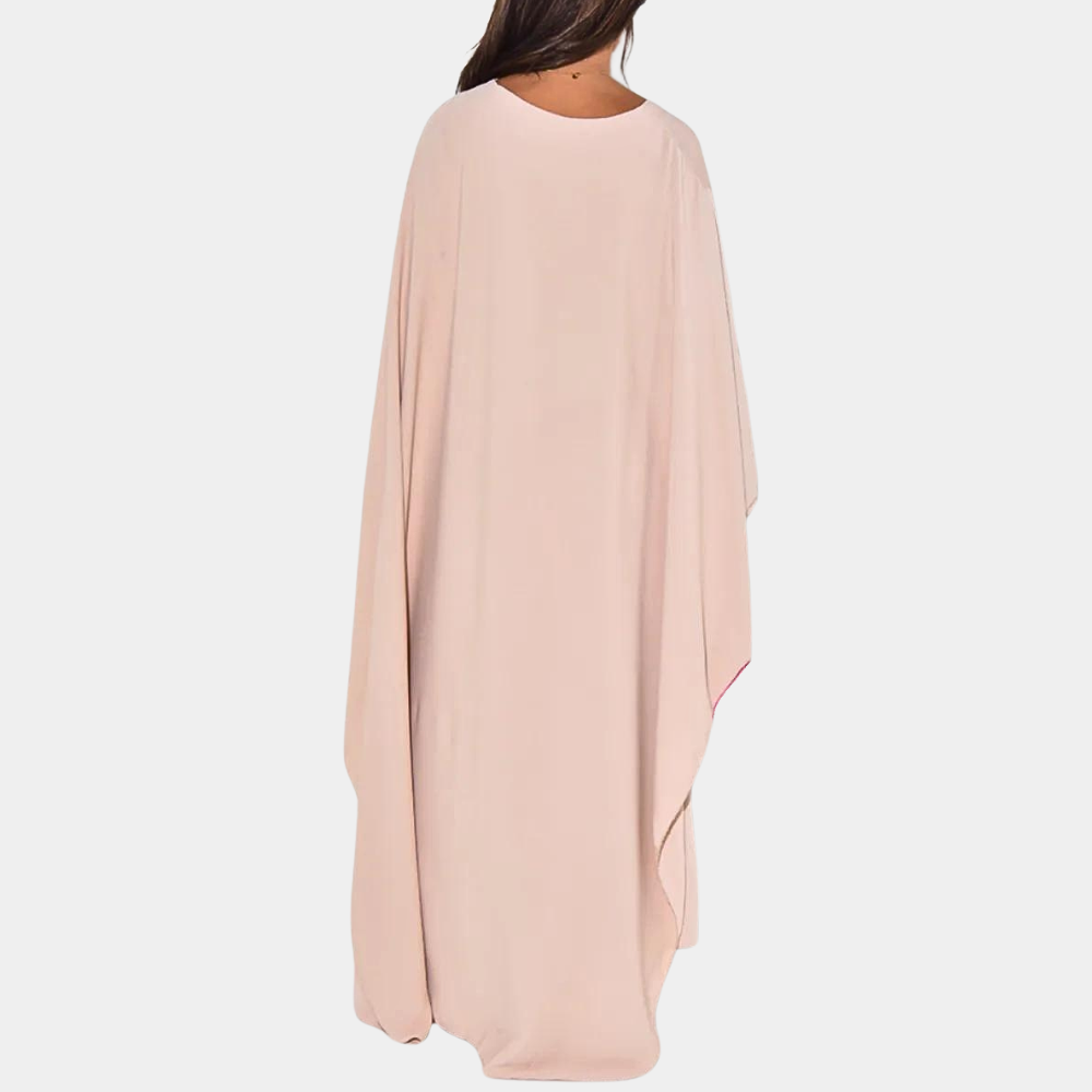 Vrouw in roze kaftan jurk, achterkant. Stijlvolle damesmode, comfortabele pasvorm, ideaal voor zomer en strand. Elegante, luchtige kleding.