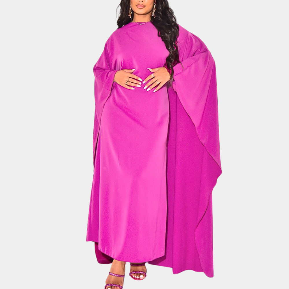 Vrouw in felroze kaftan jurk met wijde mouwen, modieuze avondkleding, elegante stijl, trendy damesmode, comfortabele pasvorm.
