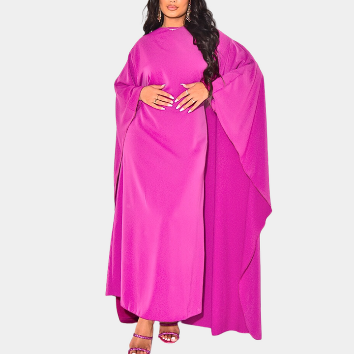 Vrouw in felroze kaftan jurk met wijde mouwen, modieuze avondkleding, elegante stijl, trendy damesmode, comfortabele pasvorm.