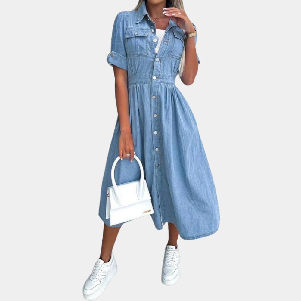 Blauwe denim jurk met knoopsluiting, korte mouwen en tailleband, gecombineerd met witte sneakers en een witte handtas. Perfect voor casual damesmode.