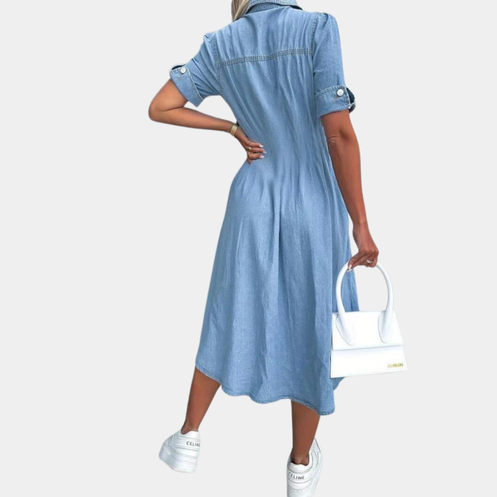 Vrouw in blauwe denim jurk met korte mouwen, witte sneakers en witte handtas. Modieuze casual outfit, perfect voor dagelijks gebruik.