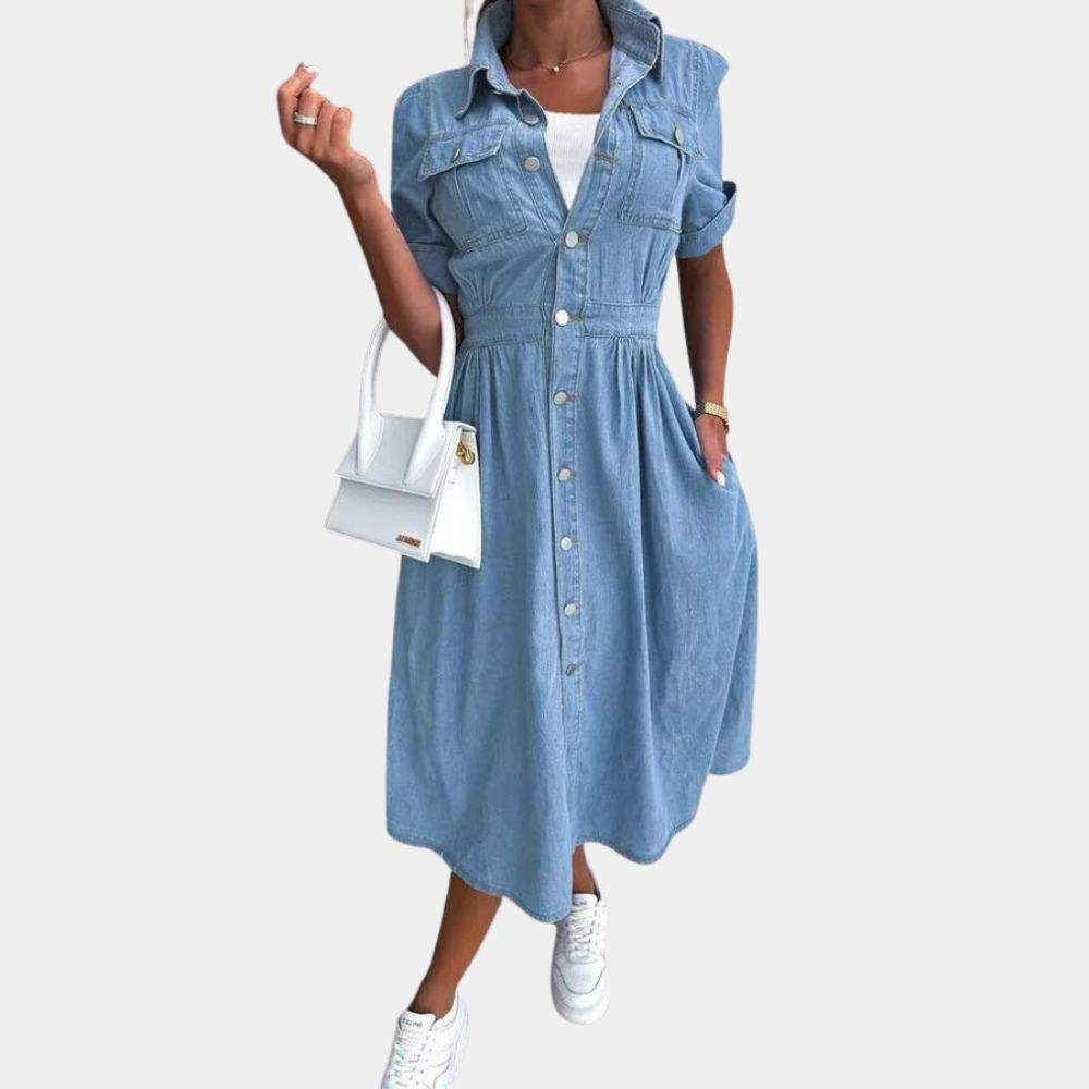 Vrouw in blauwe denim jurk met knoopsluiting, witte sneakers en witte handtas. Casual mode, dameskleding, trendy outfit.