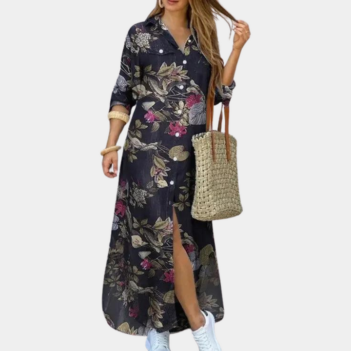 Zwarte maxi-jurk met bloemenprint, lange mouwen en knoopsluiting. Vrouw draagt rieten tas en witte sneakers. Modieuze dameskleding.