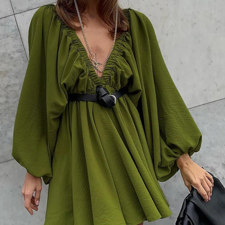 Groene jurk met diepe V-hals en pofmouwen, gedragen met zwarte riem en ketting. Modieuze dameskleding, trendy outfit voor speciale gelegenheden.