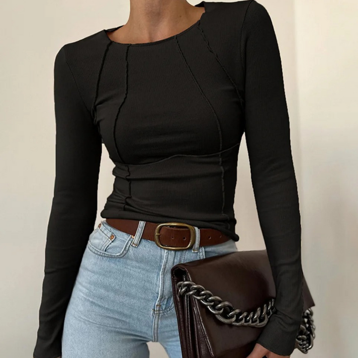 Zwarte dames top met lange mouwen, gecombineerd met lichtblauwe jeans en bruine riem. Modieuze outfit, ideaal voor casual en chique gelegenheden.