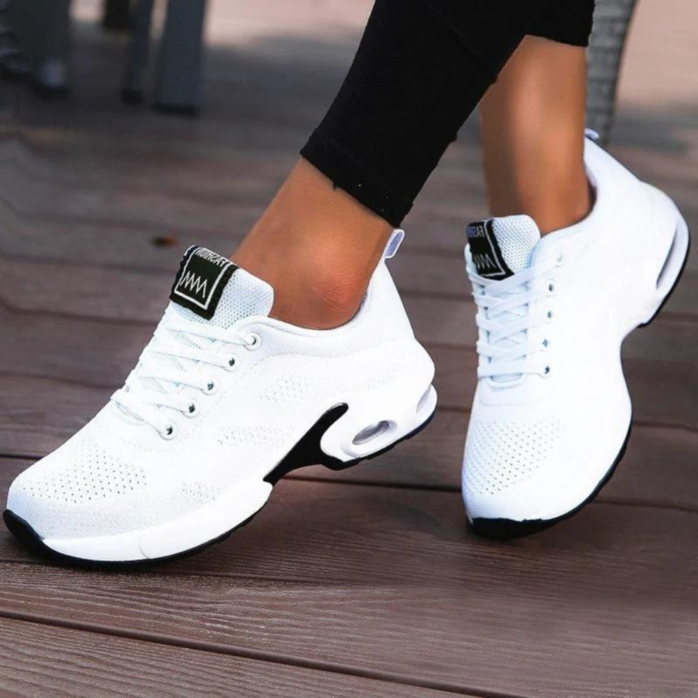 Witte dames sneakers met ademend mesh, comfortabele zool en zwarte accenten. Perfect voor sport en casual outfits. Trendy en veelzijdig schoeisel.