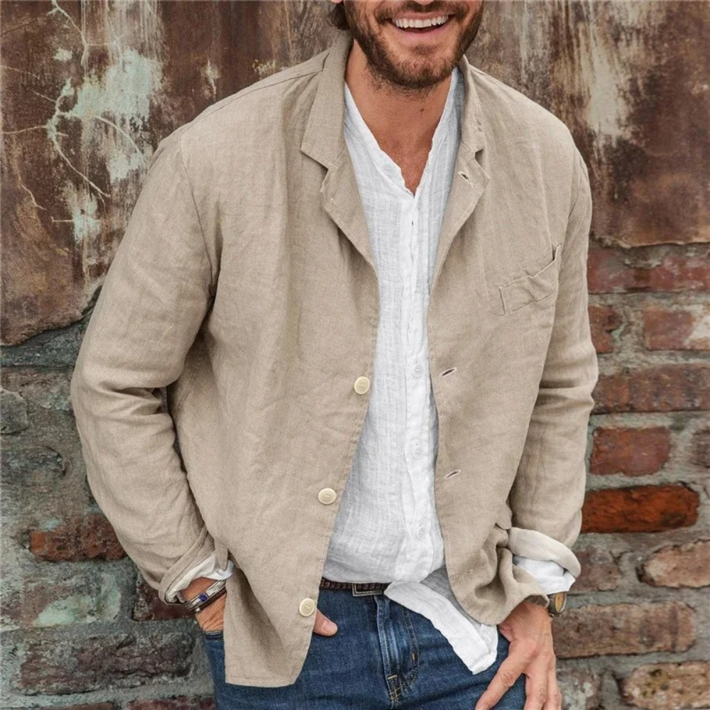 Man in casual khaki linnen blazer en witte overhemd, tegen een bakstenen muur. Stijlvolle herenkleding, ontspannen en modieuze look.