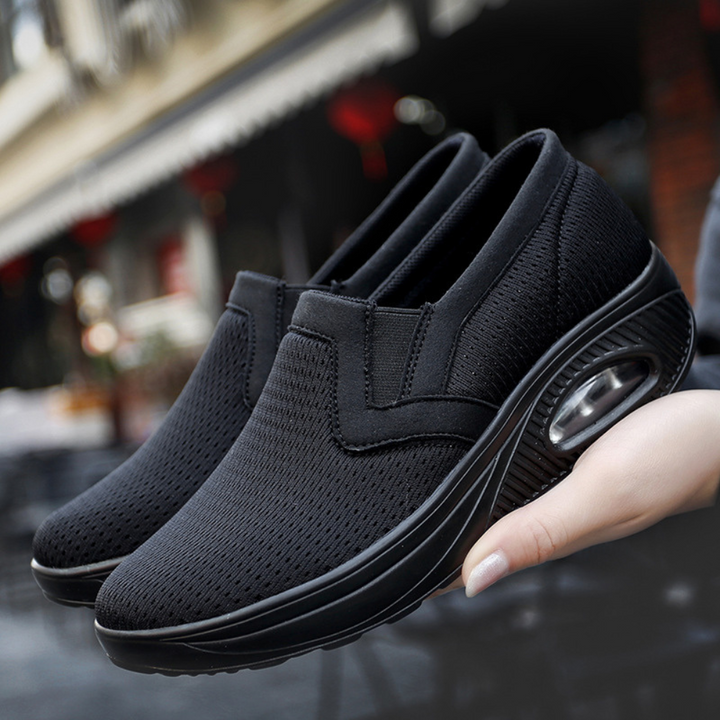 Zwarte dames sneakers met ademend mesh, slip-on design en luchtkussen zool. Comfortabele en modieuze schoenen voor dagelijks gebruik.