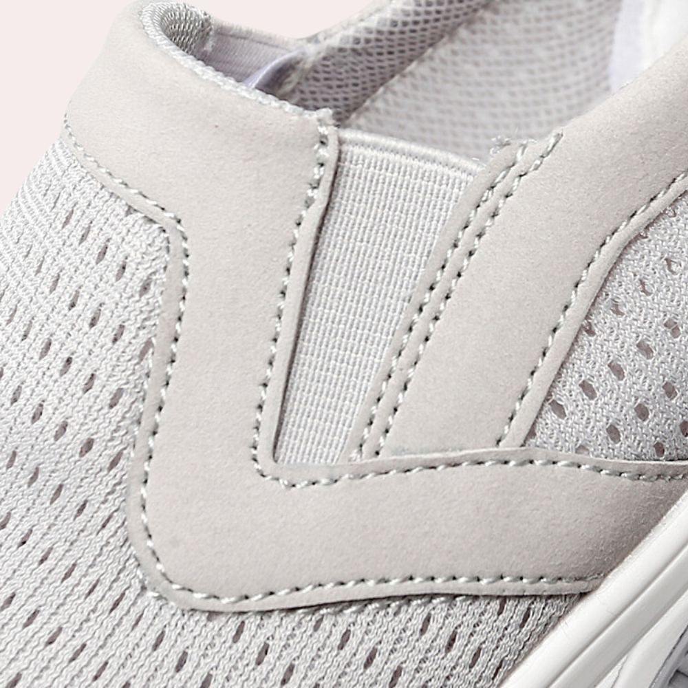 Grijze ademende sneaker met elastische inzet, mesh bovenwerk en gestikte details. Comfortabele en stijlvolle schoen voor dagelijks gebruik.