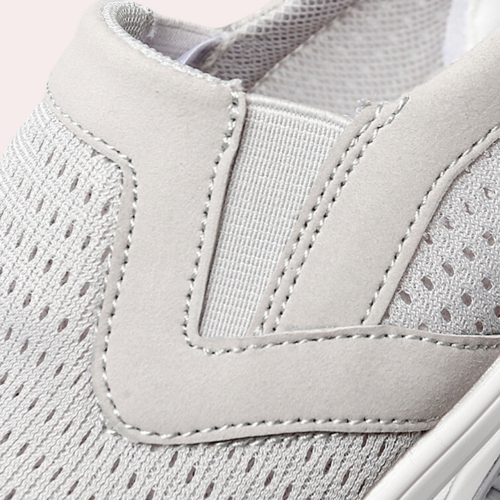 Grijze ademende sneaker met elastische inzet, mesh bovenwerk en gestikte details. Comfortabele en stijlvolle schoen voor dagelijks gebruik.