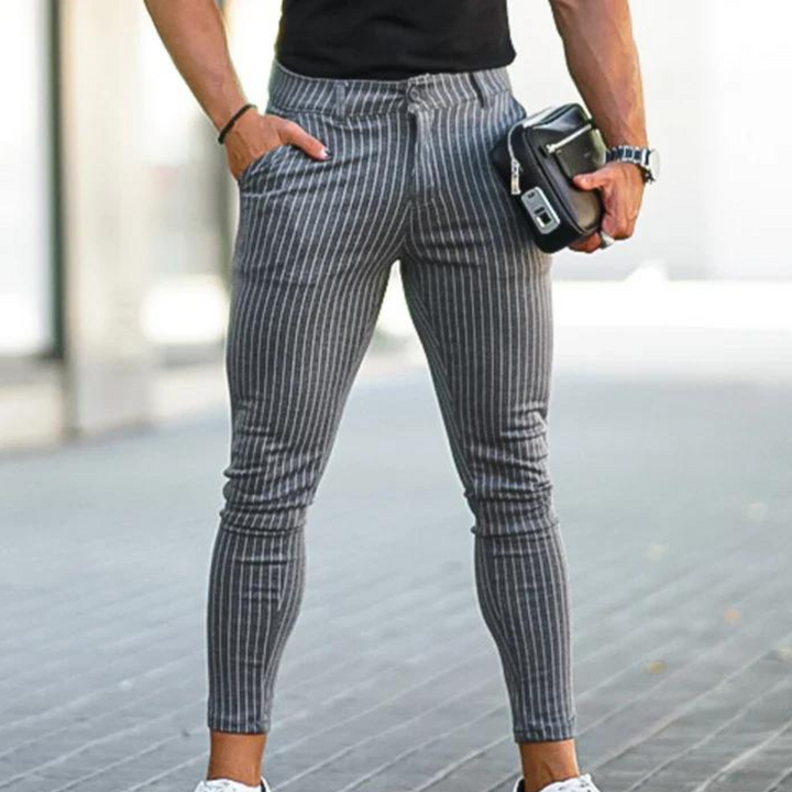 Grijze gestreepte herenbroek, slim fit, gedragen door een man met zwarte tas en horloge. Modieuze casual stijl, ideaal voor dagelijks gebruik.