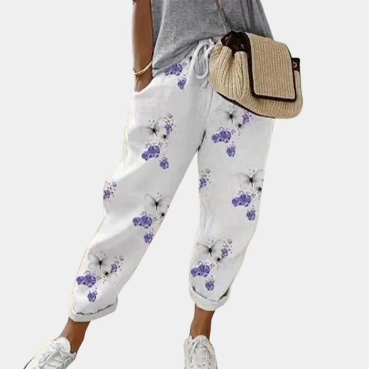 Witte damesbroek met paarse bloemenprint, casual stijl, elastische tailleband, comfortabele pasvorm, ideaal voor lente- en zomermode.