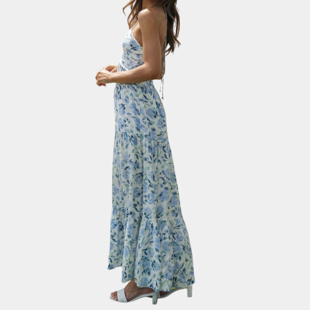 Vrouw in blauwe bloemenjurk, strapless maxi-stijl, zijaanzicht. Zomermode, elegante dameskleding, casual chic outfit.
