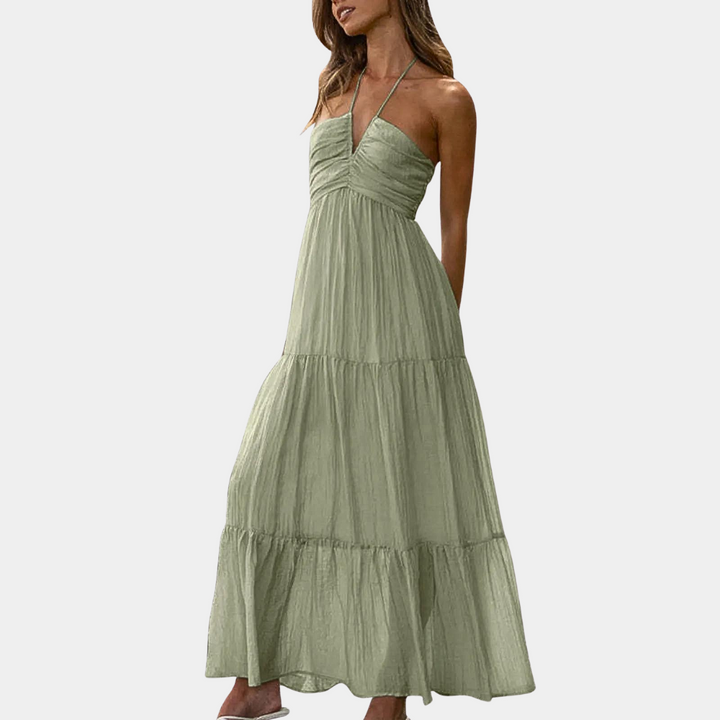Groene maxi-jurk met halternek, geplooide details en vloeiende rok. Perfect voor zomerse gelegenheden. Trendy damesmode, elegante stijl.