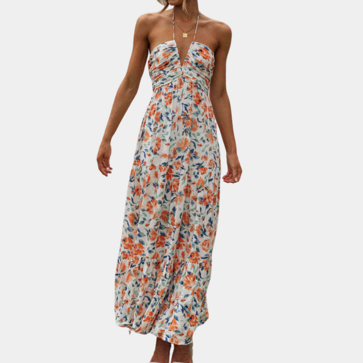 Oranje bloemenjurk met strapless ontwerp, vloeiende pasvorm en zomerse print. Perfect voor casual en elegante gelegenheden. Trendy damesmode.