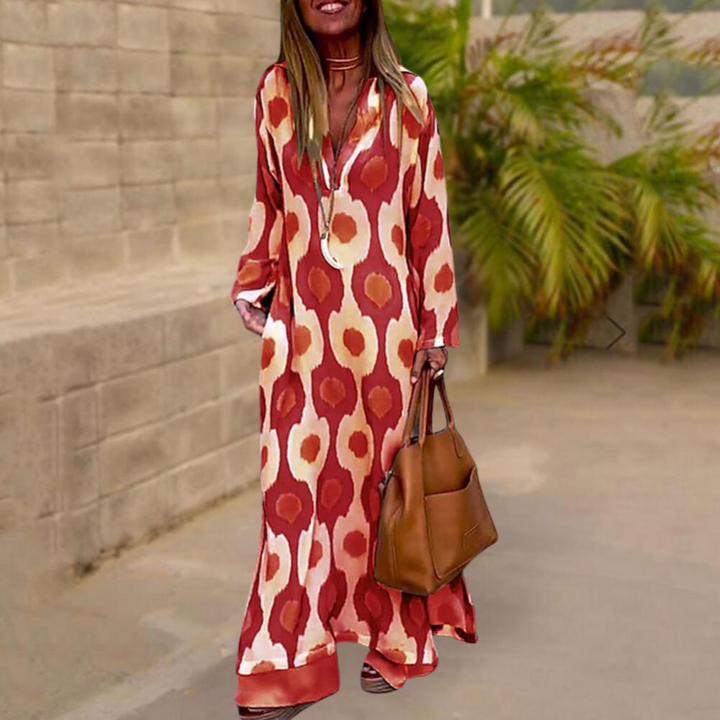 Vrouw in lange, rood-witte jurk met bloemenpatroon, draagt bruine handtas. Stijlvolle zomeroutfit, casual mode, buitenomgeving.