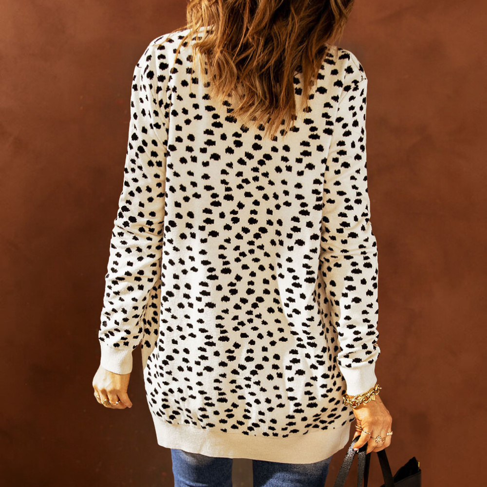Vrouw in lange, beige trui met zwarte stippen, casual mode, herfstkleding, trendy dameskleding, rugaanzicht, bruine achtergrond.