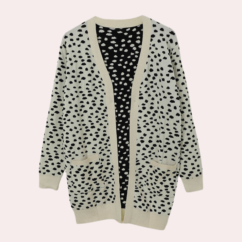 Lange beige damesvest met zwarte stippen, open voorkant en zakken. Modieuze cardigan, ideaal voor herfst- en wintermode.