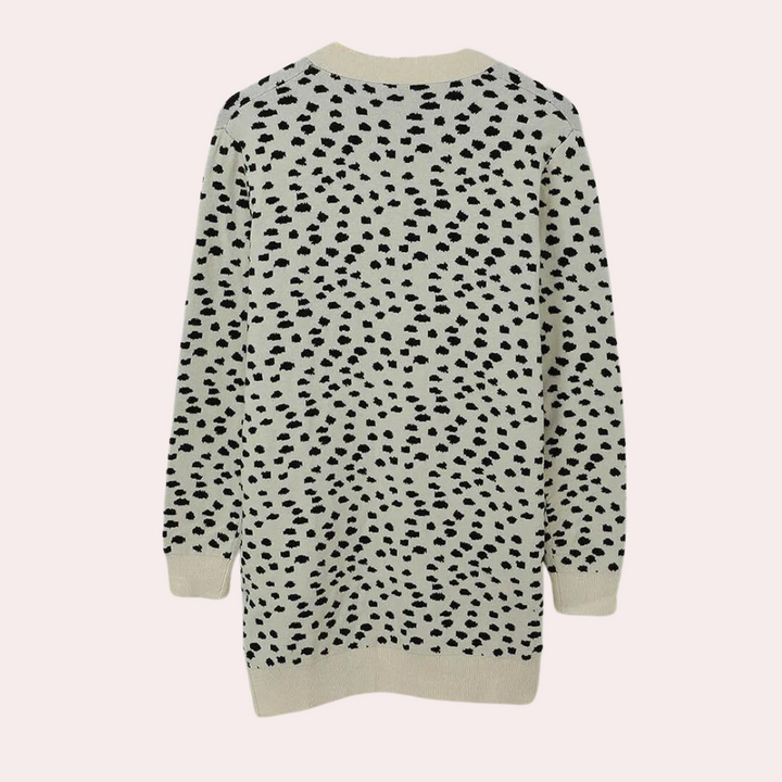 Achterkant van een beige damestrui met zwarte luipaardprint, lange mouwen en ronde hals. Modieuze trui, perfect voor herfst- en winteroutfits.