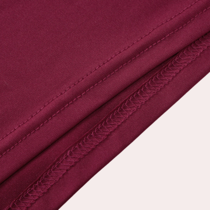 Wijnrode stof close-up met zichtbare stiksels, ideaal voor modeontwerp en kledingproductie. Hoogwaardige textielmaterialen.