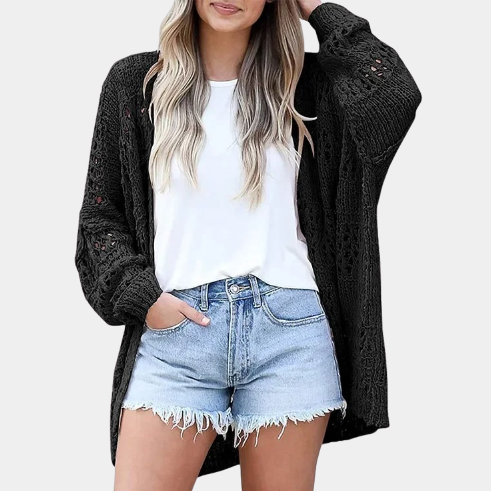 Vrouw in zwarte gebreide cardigan, witte T-shirt en denim shorts. Casual damesmode, trendy zomeroutfit, comfortabele kledingstijl.