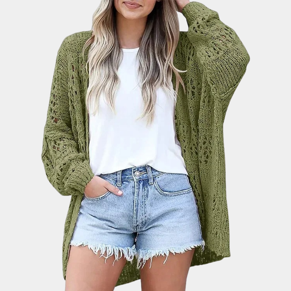Vrouw draagt groene gehaakte cardigan, witte T-shirt en denim shorts. Modieuze dameskleding, casual zomeroutfit, trendy stijl.