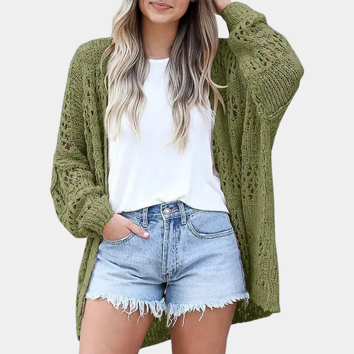 Vrouw draagt groene gehaakte cardigan, witte T-shirt en denim shorts. Modieuze dameskleding, casual zomeroutfit, trendy stijl.