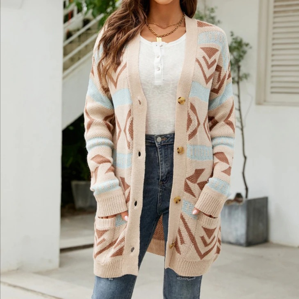 Vrouw draagt beige gebreid vest met geometrisch patroon, witte top en jeans. Stijlvolle herfstmode, comfortabele dameskleding, casual outfit.