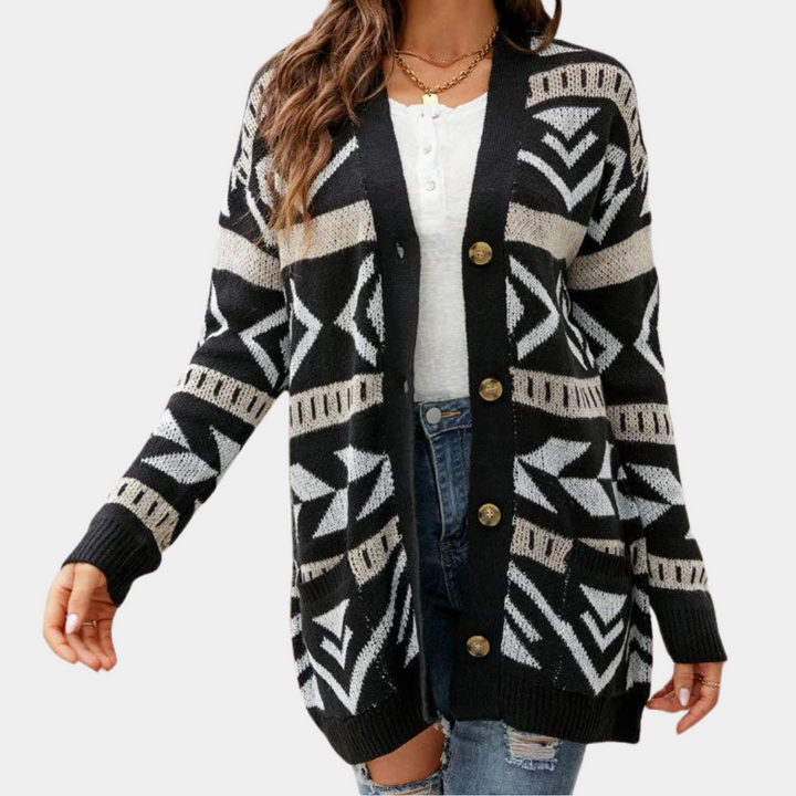 Vrouw draagt zwarte gebreide cardigan met geometrisch patroon, knopen en witte top. Modieuze dameskleding, herfst-winter stijl.